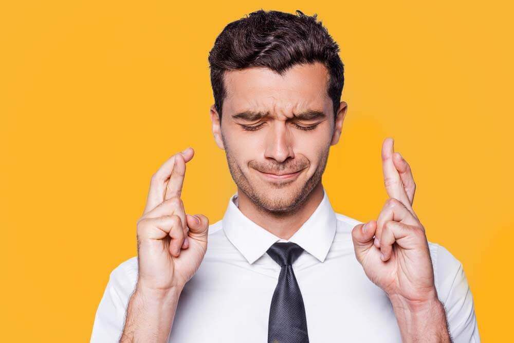 man in shirt and tie crossing fingers_Image used under licence from Shutterstock